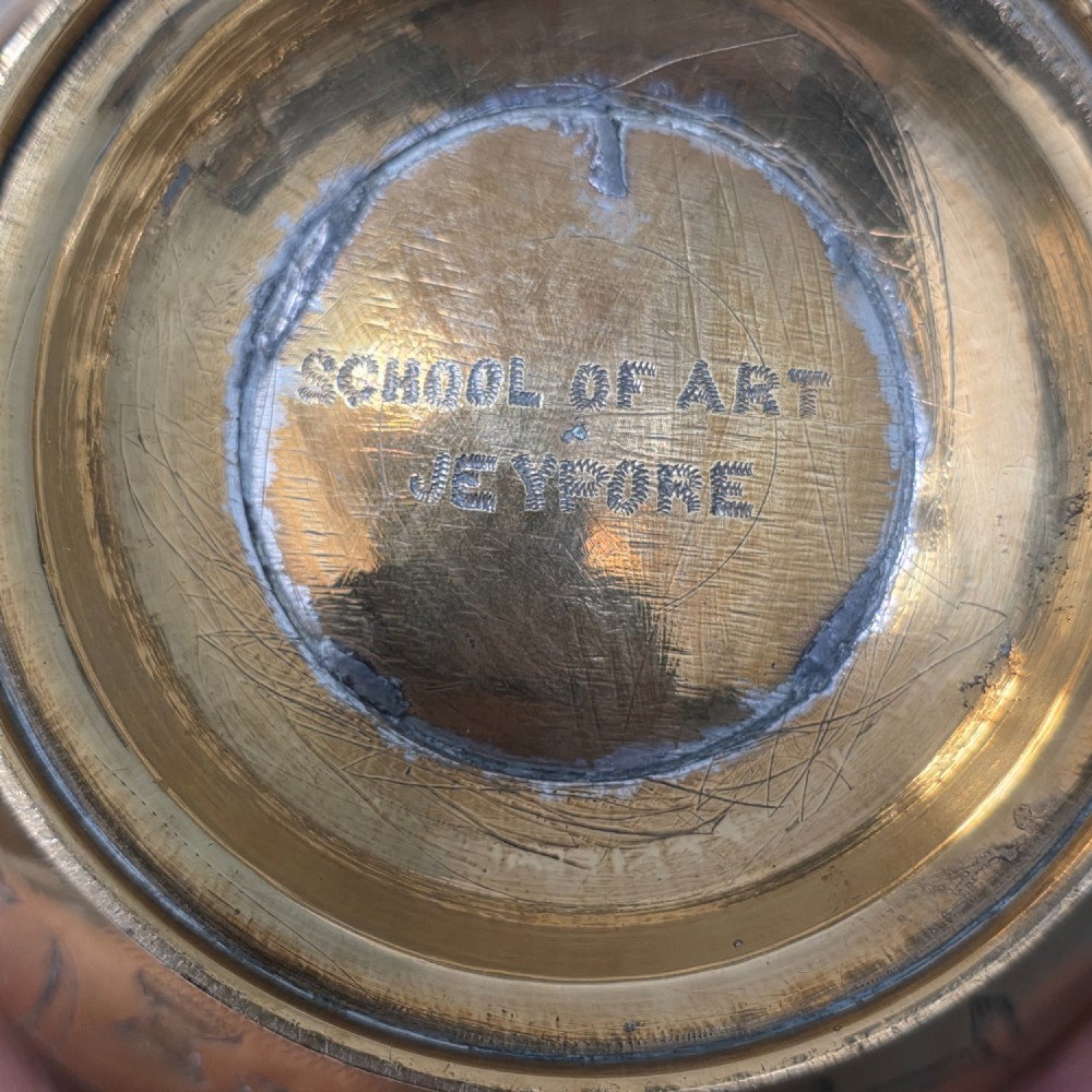 An antique Indian engraved brass kamandal vessel featuring a rounded base decorated with figures, a flared upper rim, and a high arched handle with raised knops. View XIV