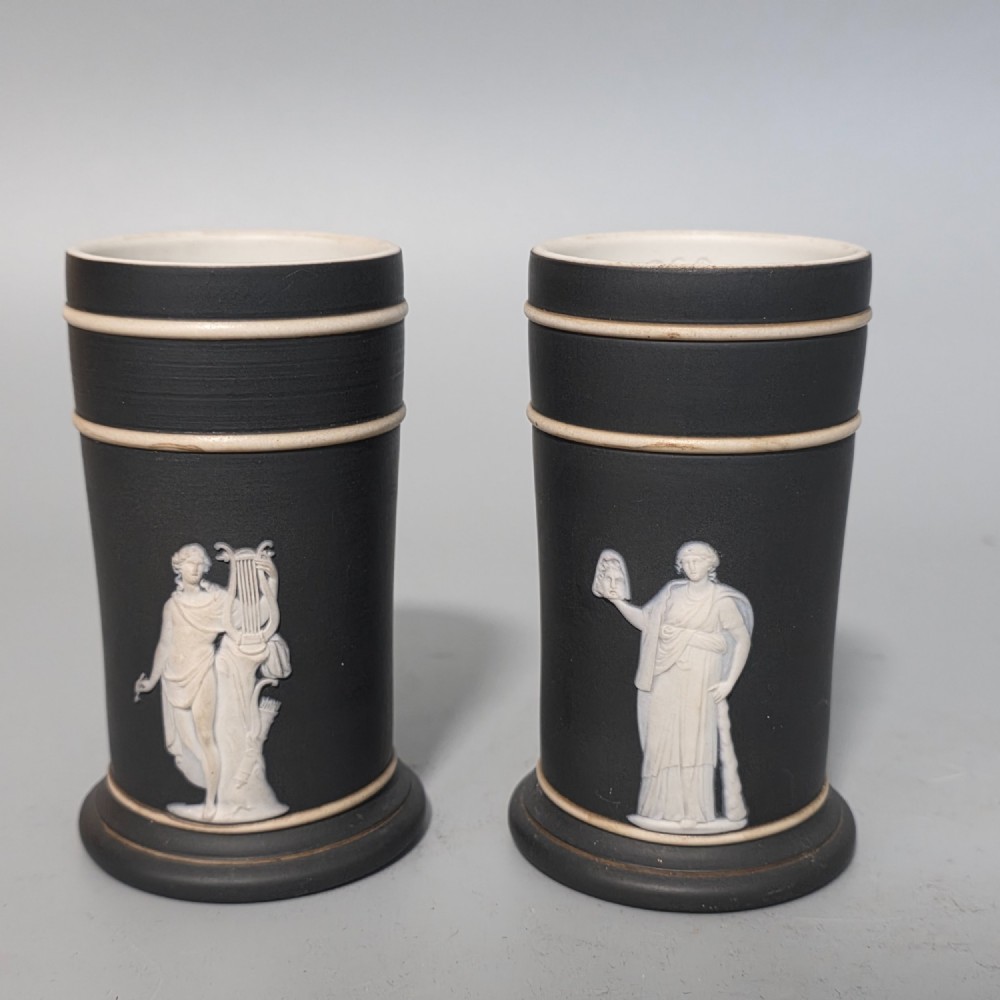 A pair of cylindrical black basalt spill holders featuring raised white neoclassical figures and white double-banded rims. View III
