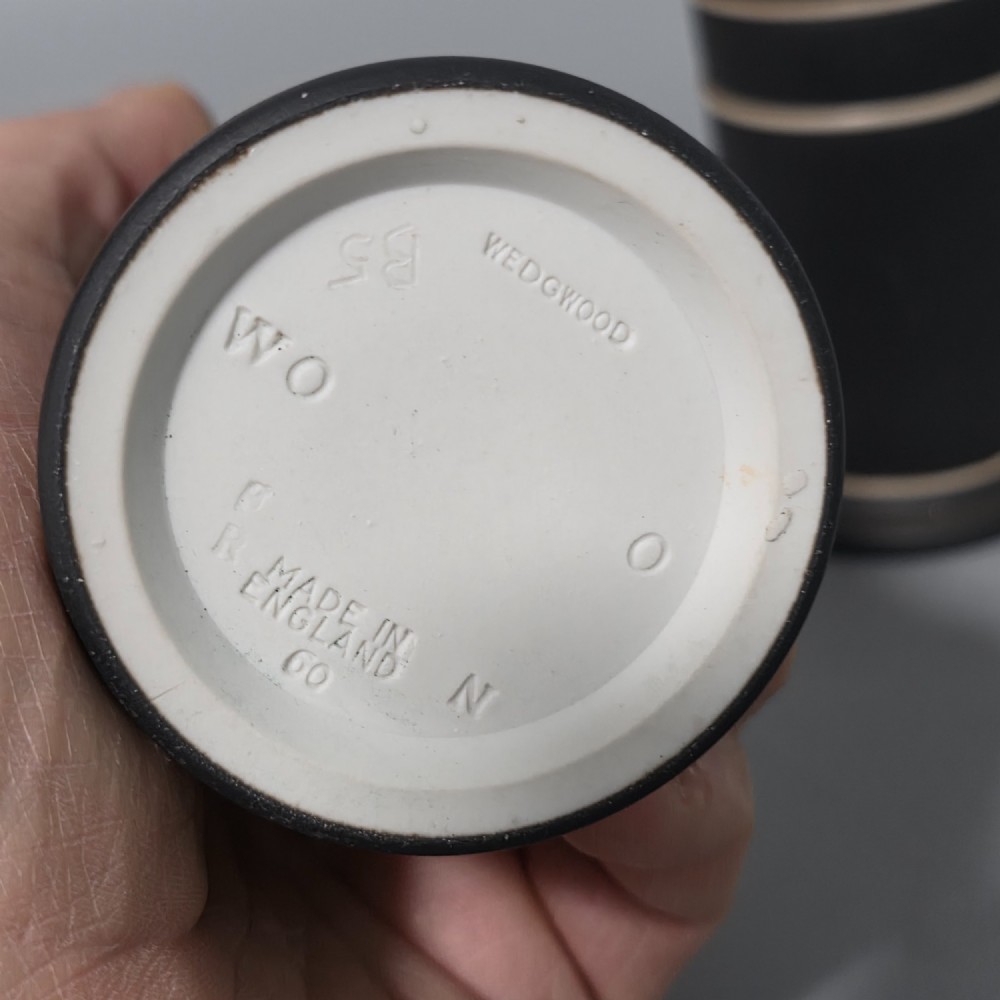 A pair of cylindrical black basalt spill holders featuring raised white neoclassical figures and white double-banded rims. View V