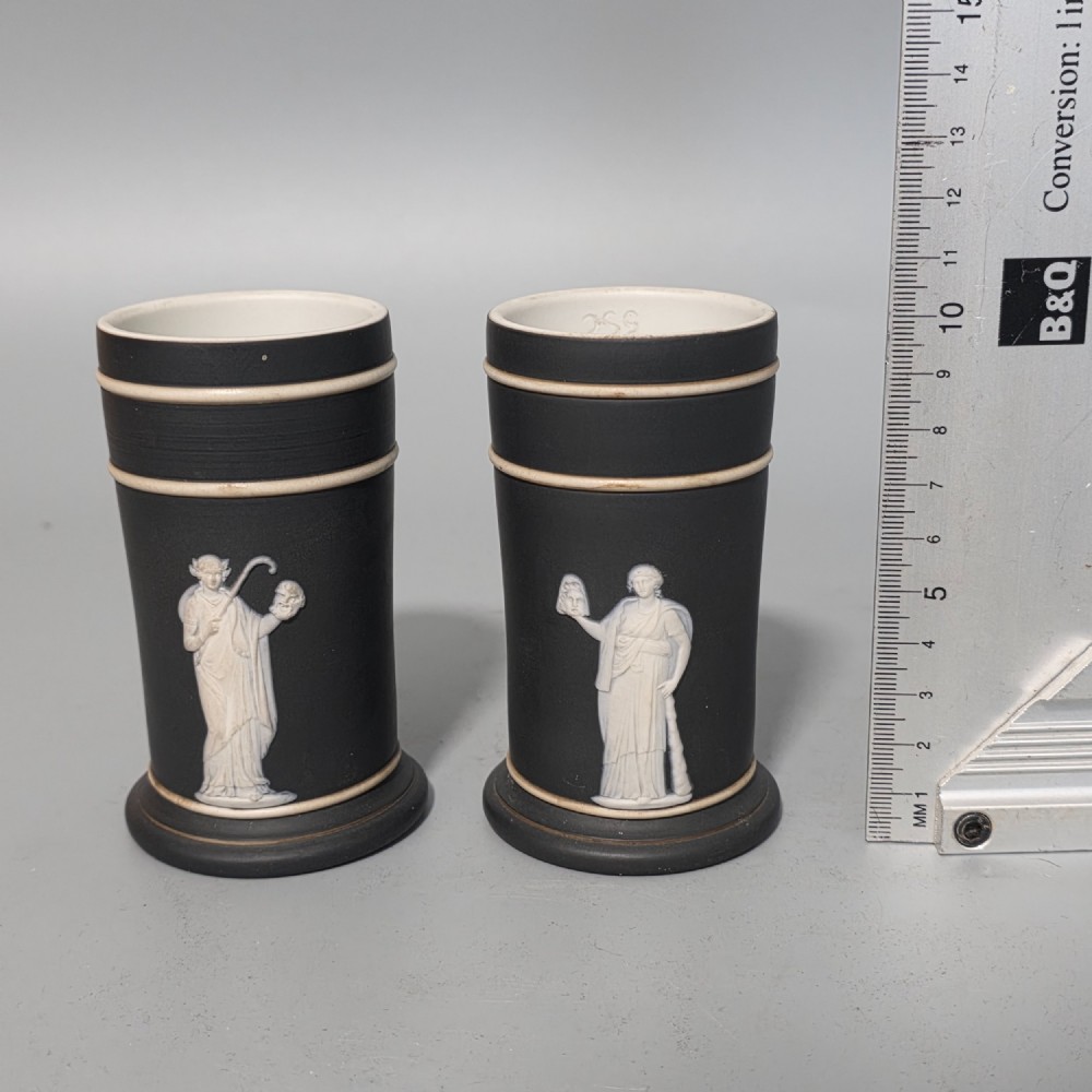 A pair of cylindrical black basalt spill holders featuring raised white neoclassical figures and white double-banded rims. View VII