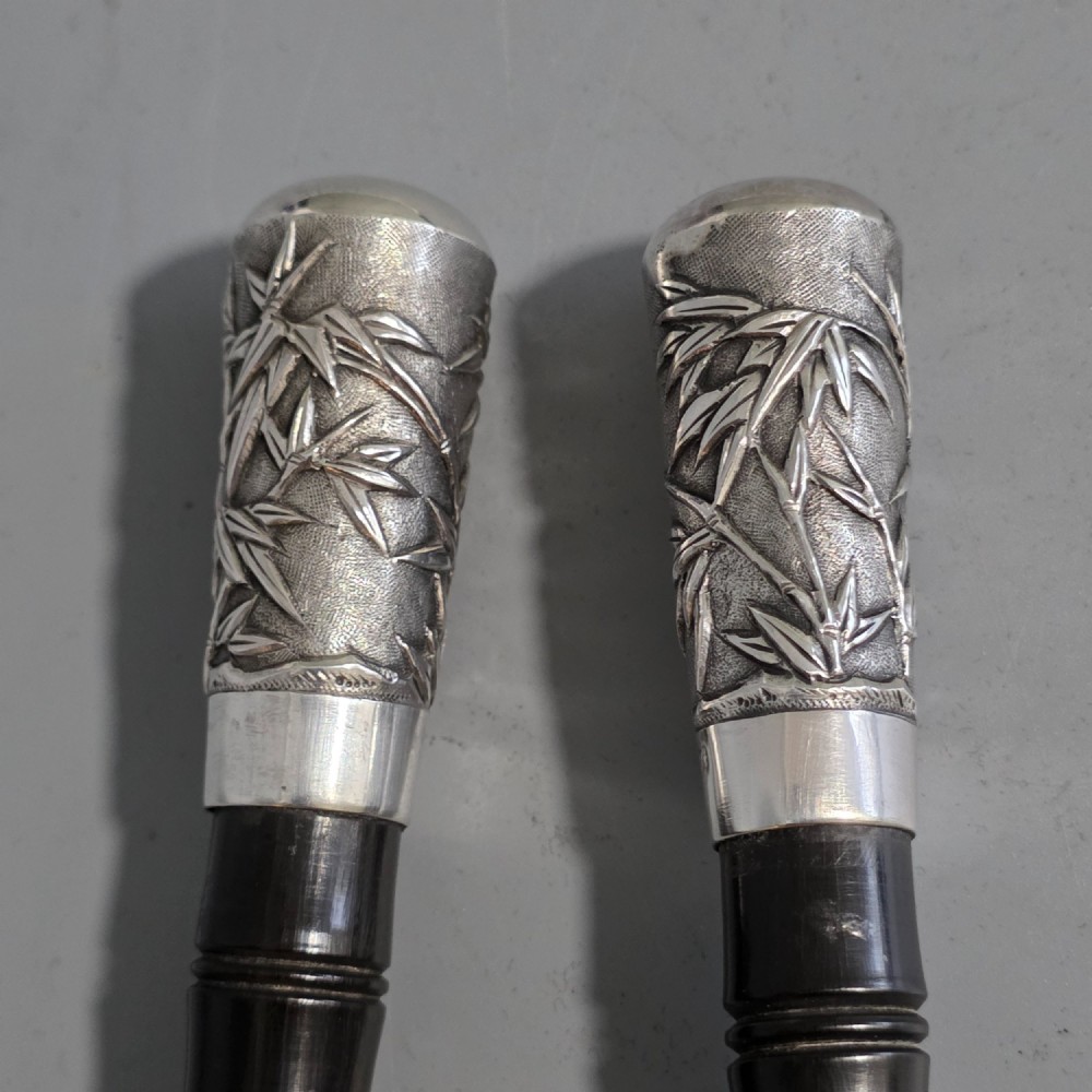 A pair of Chinese export silver salad servers featuring carved shell bowls, dark wooden bamboo-form handles, and silver terminal caps chased with bamboo leaves. View III