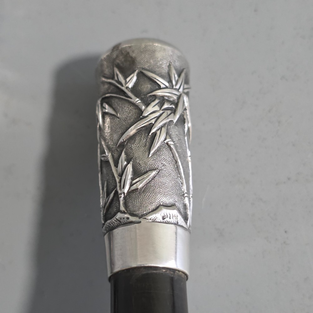 A pair of Chinese export silver salad servers featuring carved shell bowls, dark wooden bamboo-form handles, and silver terminal caps chased with bamboo leaves. View IV