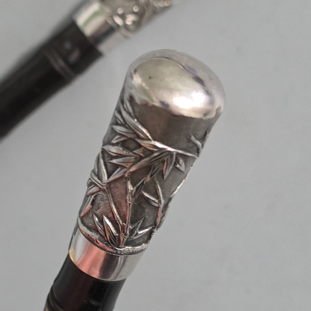 A pair of Chinese export silver salad servers featuring carved shell bowls, dark wooden bamboo-form handles, and silver terminal caps chased with bamboo leaves. View IX