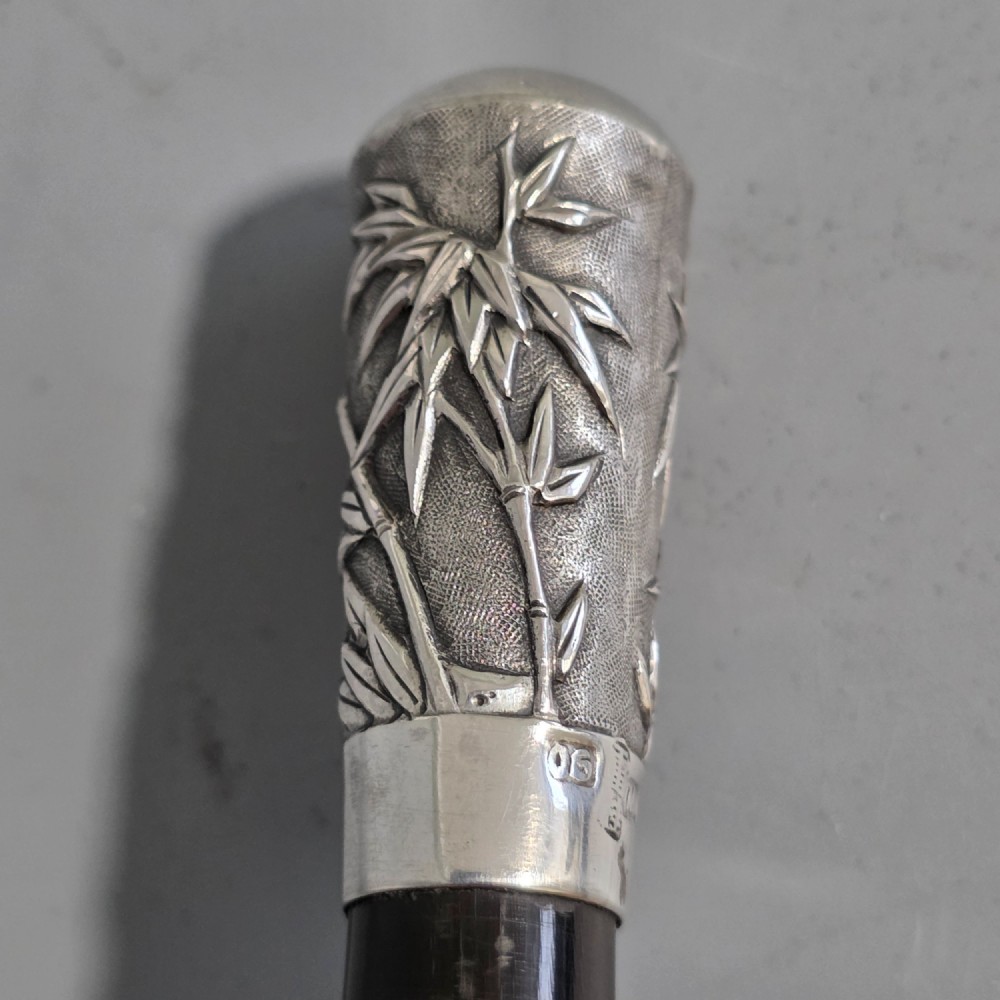 A pair of Chinese export silver salad servers featuring carved shell bowls, dark wooden bamboo-form handles, and silver terminal caps chased with bamboo leaves. View X