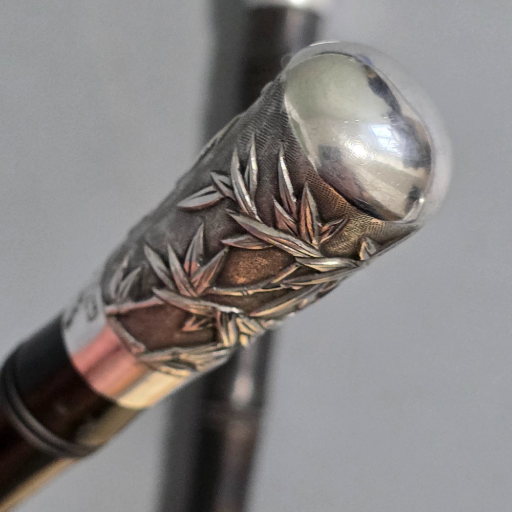 A pair of Chinese export silver salad servers featuring carved shell bowls, dark wooden bamboo-form handles, and silver terminal caps chased with bamboo leaves. View XII