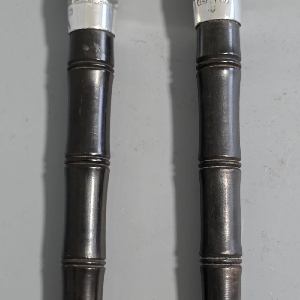 A pair of Chinese export silver salad servers featuring carved shell bowls, dark wooden bamboo-form handles, and silver terminal caps chased with bamboo leaves. View XIII