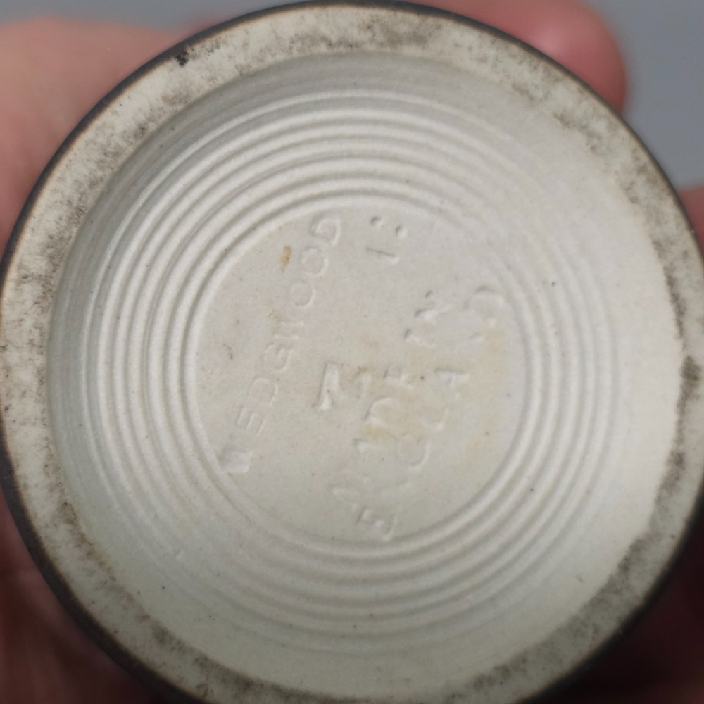 A cylindrical black stoneware Wedgwood match striker featuring white classical relief figures and floral garlands. View VIII