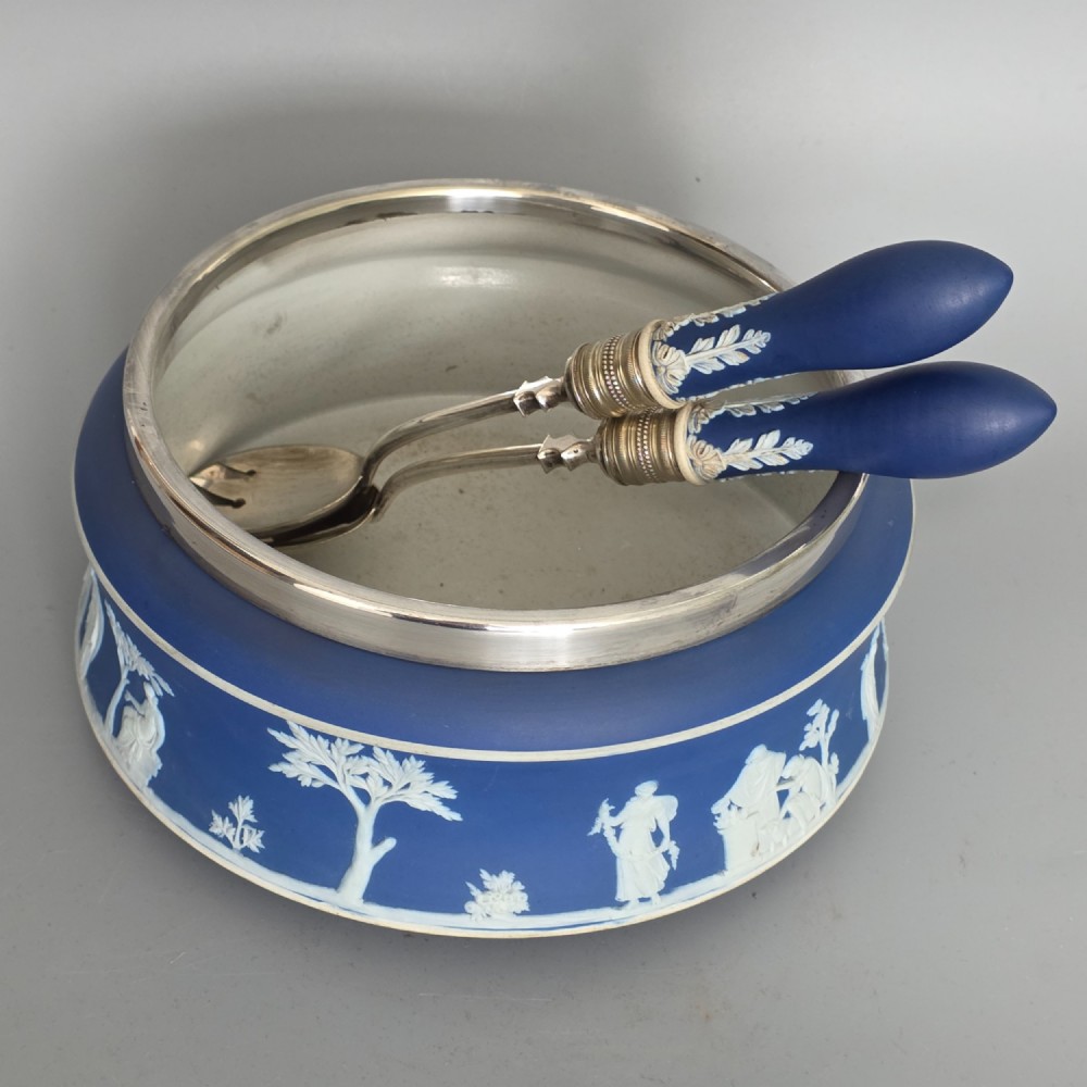 A Victorian Wedgwood blue jasperware salad bowl with a silver-plated rim, decorated with white neoclassical relief figures, complete with matching blue and silver servers.