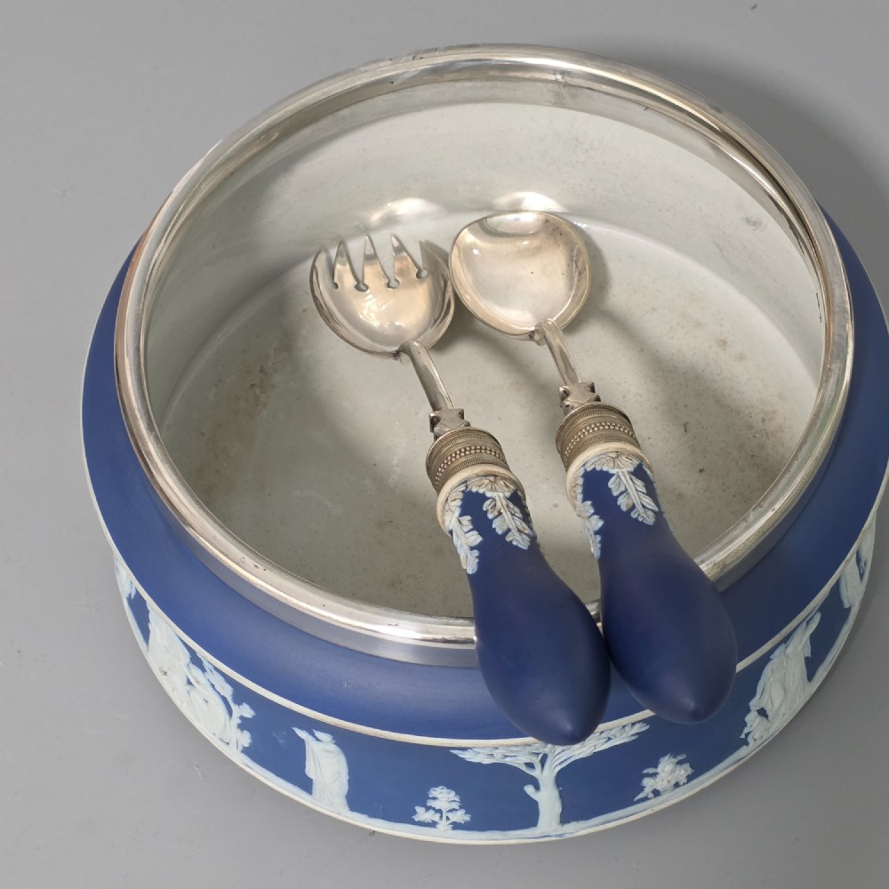 A Victorian Wedgwood blue jasperware salad bowl with a silver-plated rim, decorated with white neoclassical relief figures, complete with matching blue and silver servers. View V