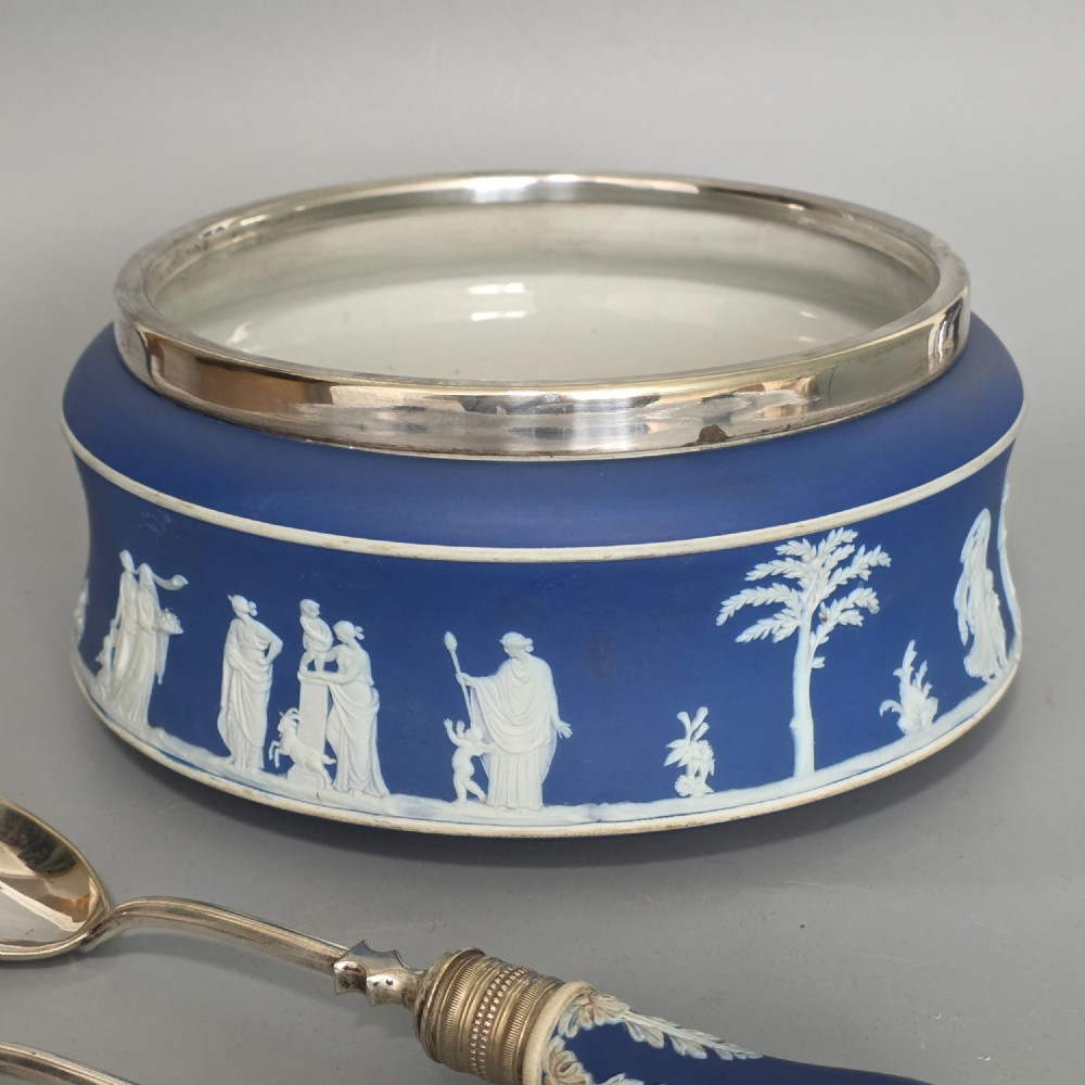 A Victorian Wedgwood blue jasperware salad bowl with a silver-plated rim, decorated with white neoclassical relief figures, complete with matching blue and silver servers. View XV