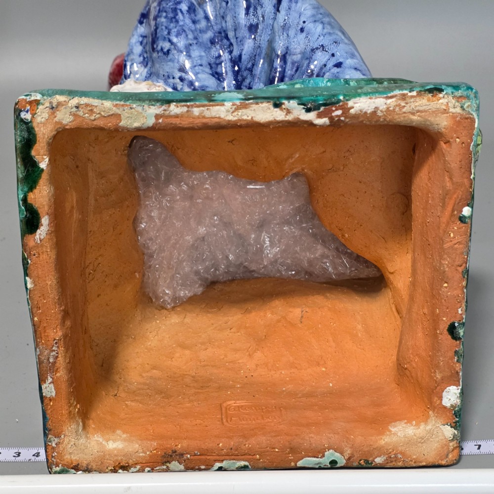A polychrome glazed ceramic sculpture depicting an enthroned Madonna holding the Christ Child with a small musical putto playing at her feet. View XV