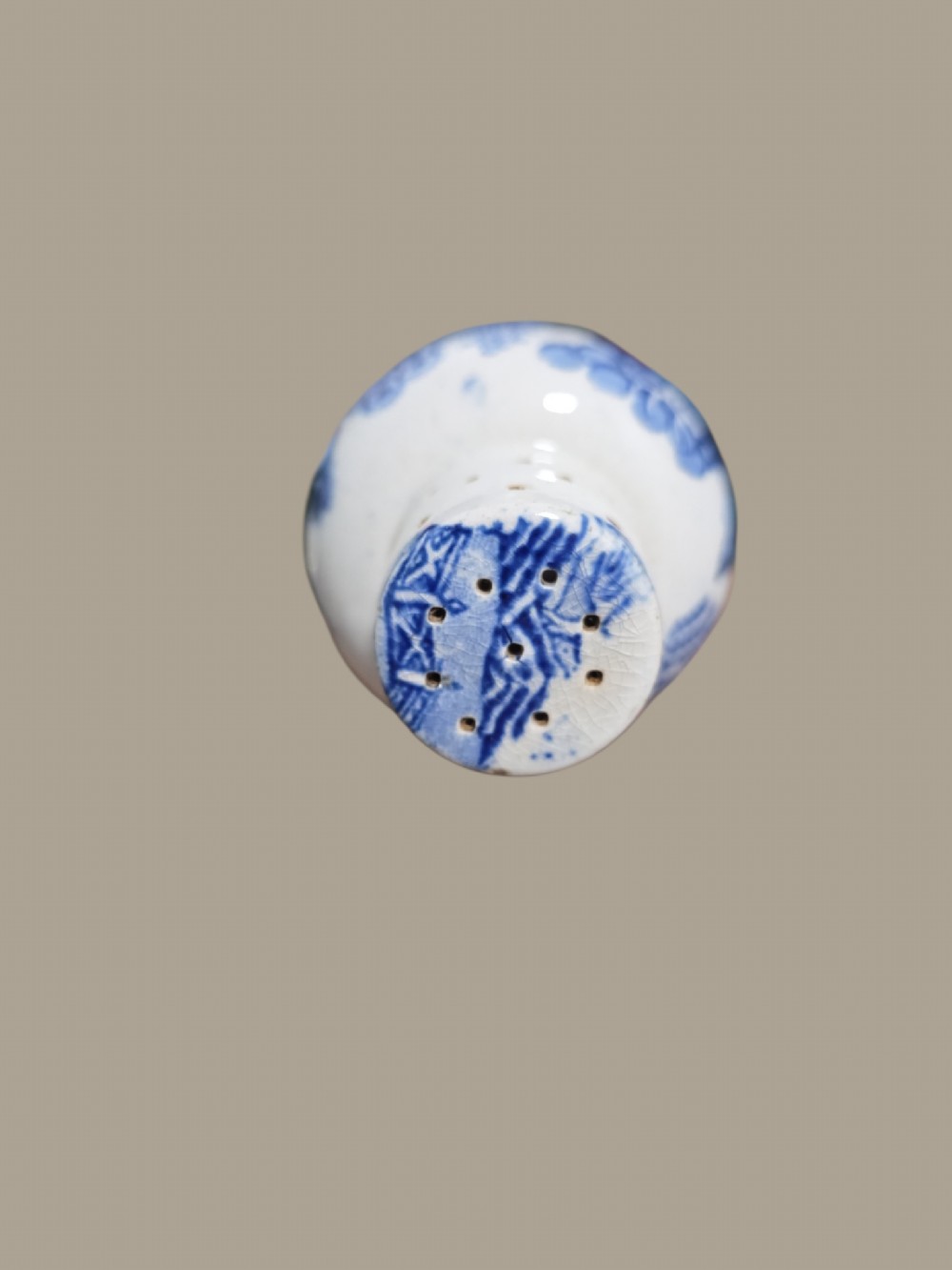 A small antique blue and white pearlware pepper pot with pierced holes on top and a transferware landscape pattern. View III