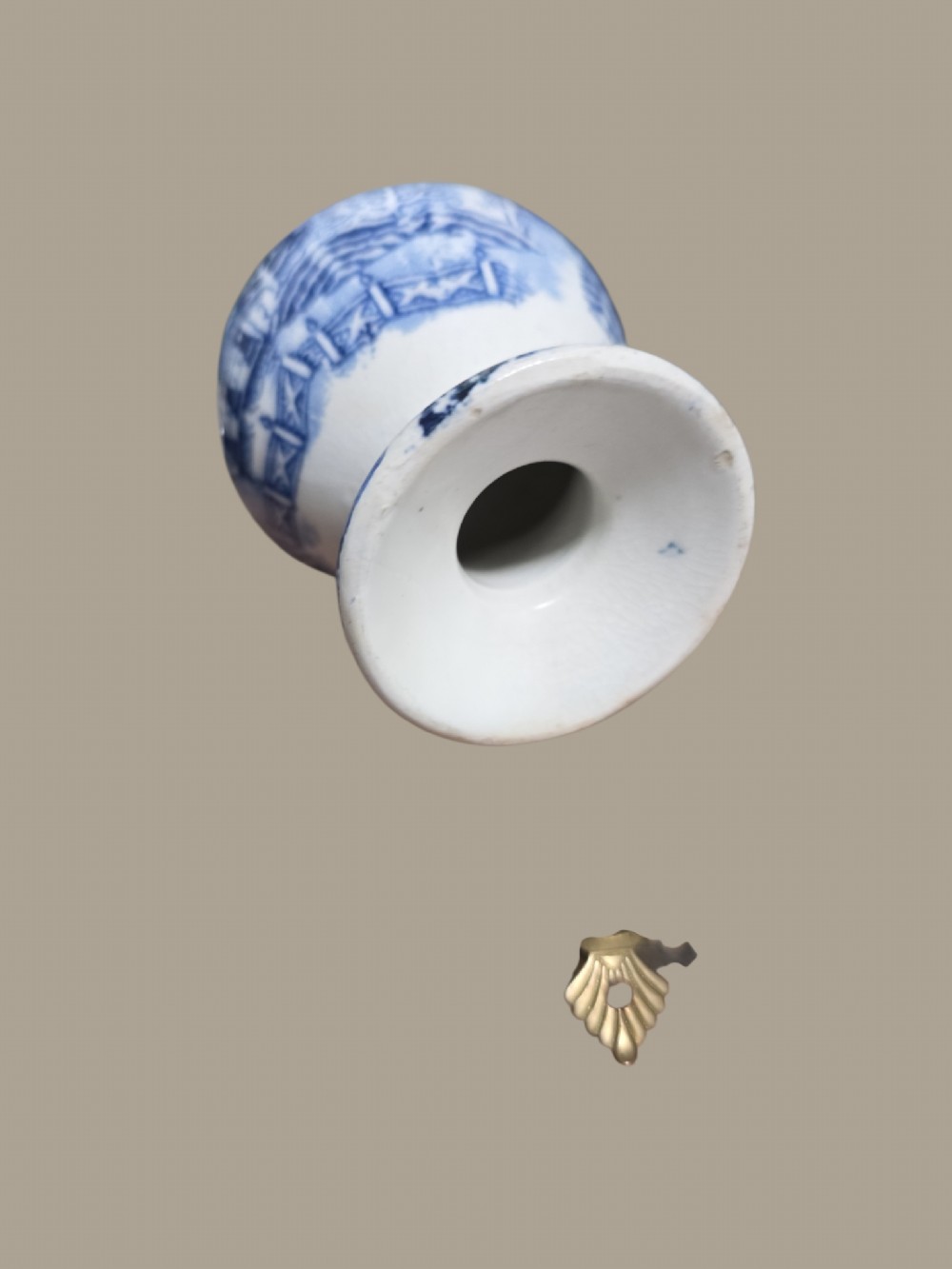 A small antique blue and white pearlware pepper pot with pierced holes on top and a transferware landscape pattern. View IV
