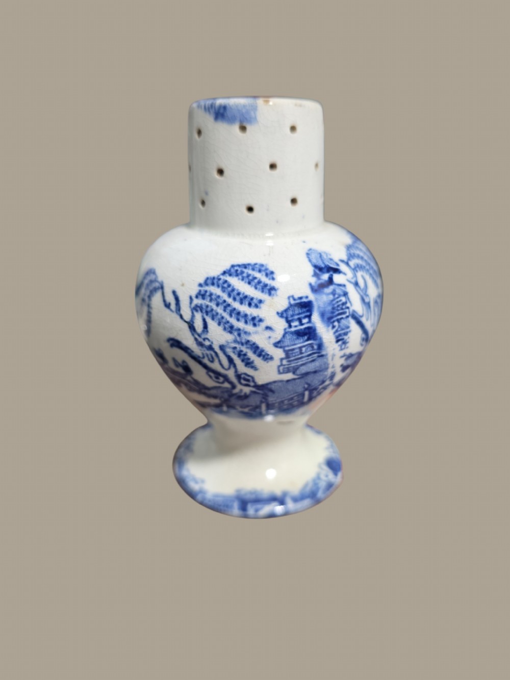 A small antique blue and white pearlware pepper pot with pierced holes on top and a transferware landscape pattern. View VIII
