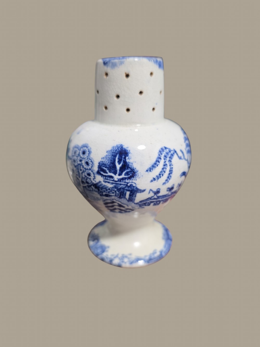 A small antique blue and white pearlware pepper pot with pierced holes on top and a transferware landscape pattern. View IX