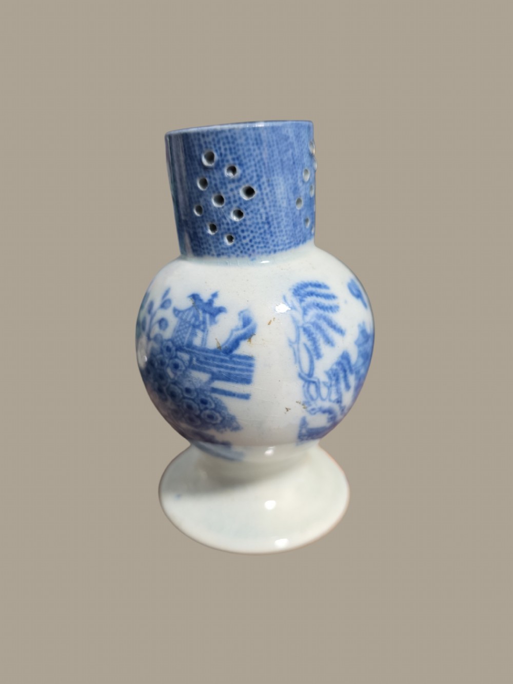 An antique blue and white pearlware pepper pot featuring transfer-printed chinoiserie motifs and a perforated cylindrical top. View II