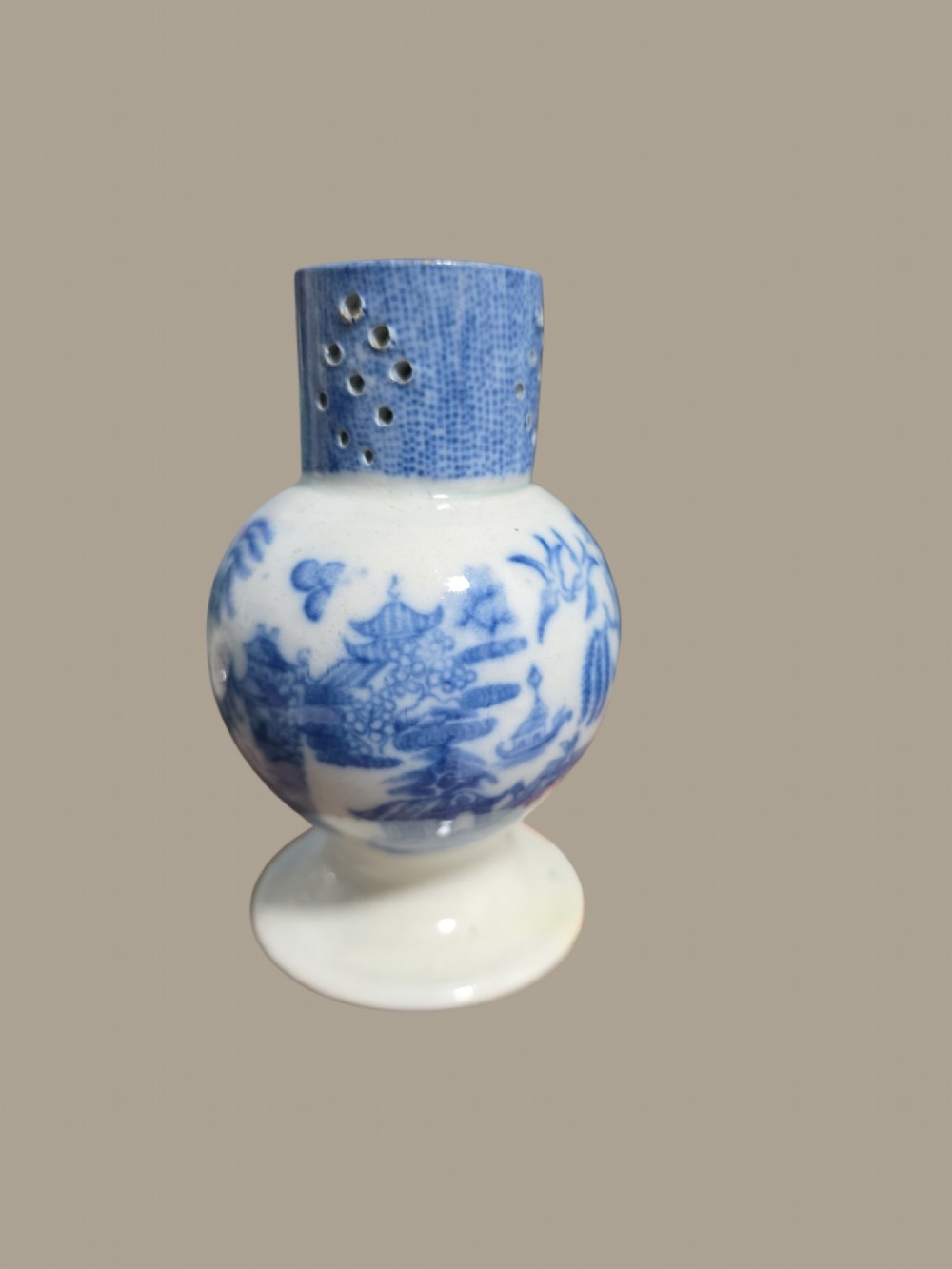 An antique blue and white pearlware pepper pot featuring transfer-printed chinoiserie motifs and a perforated cylindrical top. View X