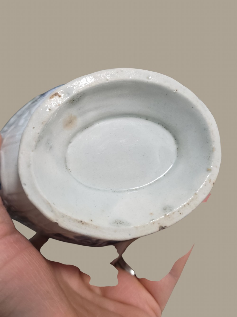 An eighteenth-century blue and white soft-paste porcelain sauce boat featuring moulded scroll decoration, a shaped rim, a scroll handle, and a printed landscape scene. View IX