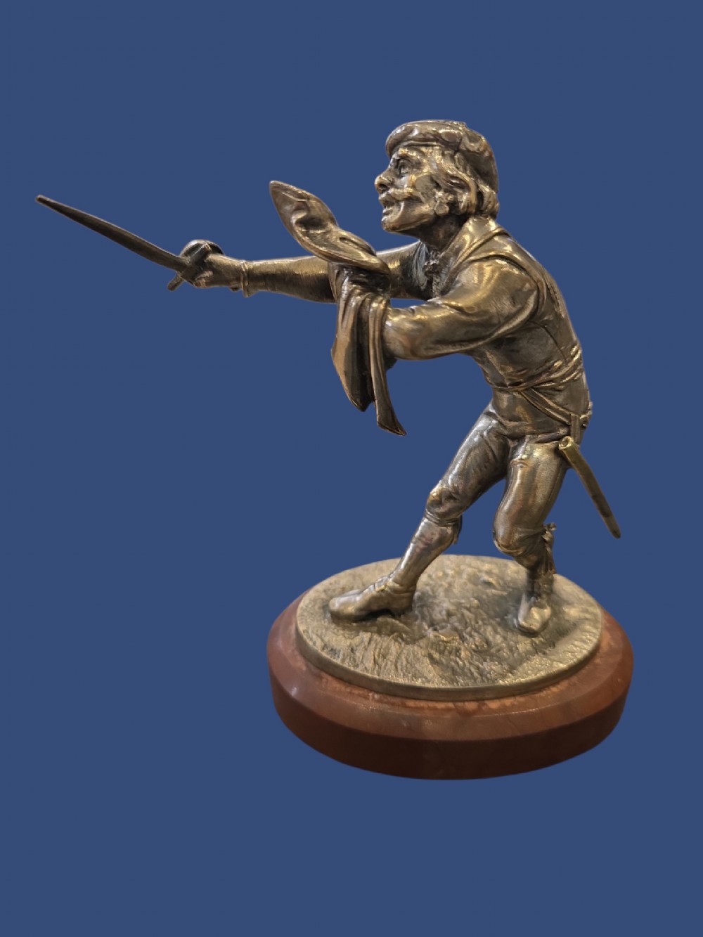A nineteenth-century silvered bronze sculpture depicting a sword-wielding cavalier posed on an oval rouge marble plinth.