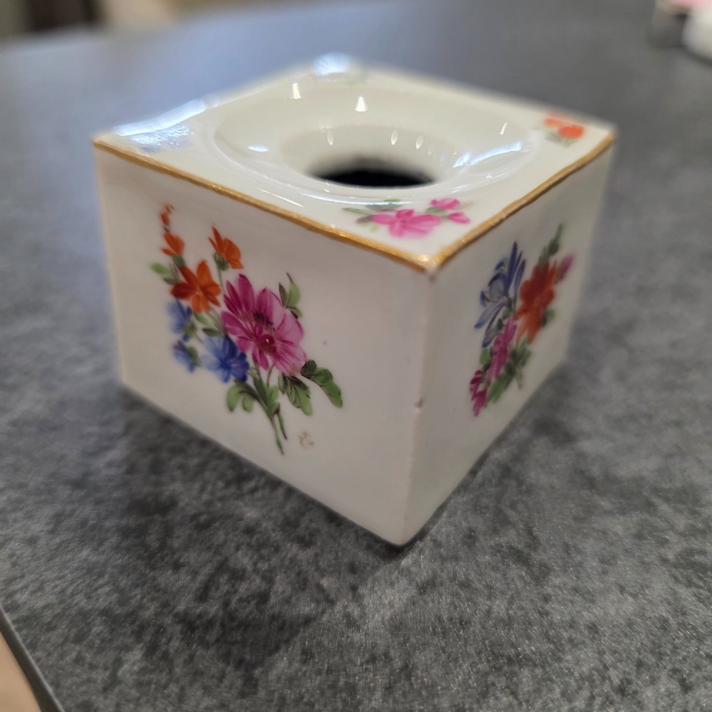A square white porcelain inkwell featuring a recessed circular top, hand-painted botanical flowers on the sides, and a gold gilded rim.