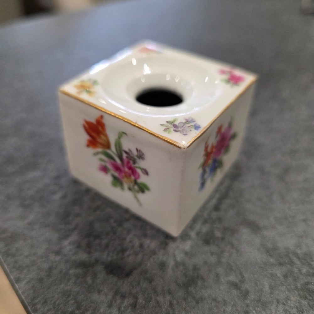 A square white porcelain inkwell featuring a recessed circular top, hand-painted botanical flowers on the sides, and a gold gilded rim. View VI