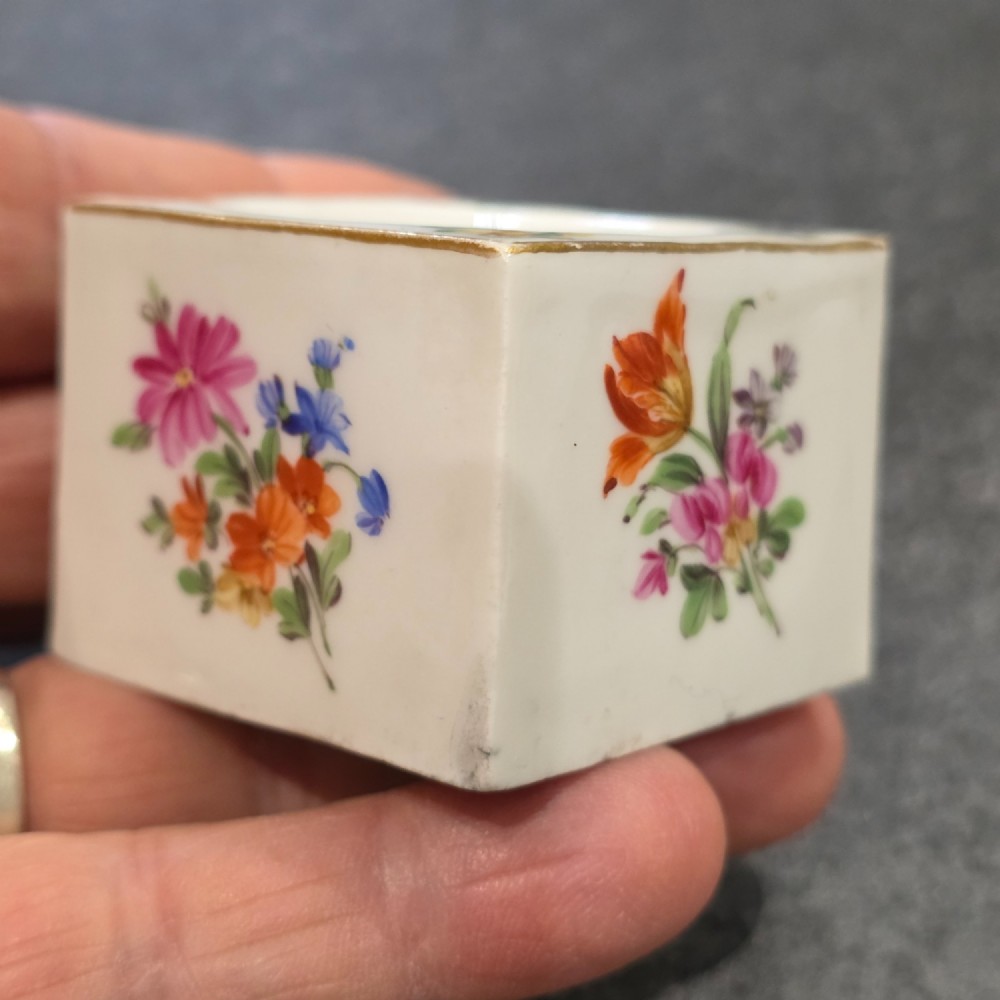 A square white porcelain inkwell featuring a recessed circular top, hand-painted botanical flowers on the sides, and a gold gilded rim. View XIII