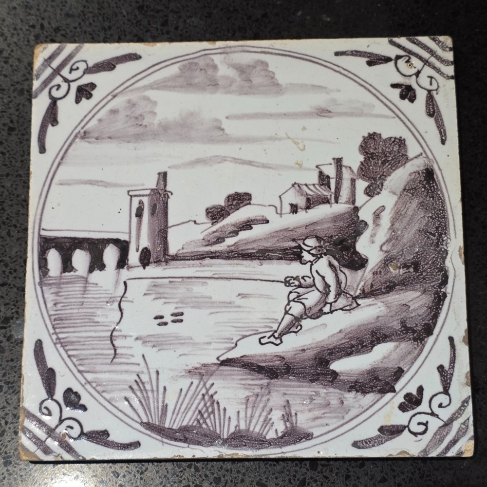 London delft tile painted in manganese with a man fishing in a river, circa 1725 - 1760