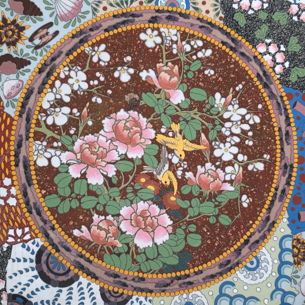 A circular Japanese cloisonne charger featuring a central medallion with birds and peonies on a brown aventurine background surrounded by patterned brocade sections. View III