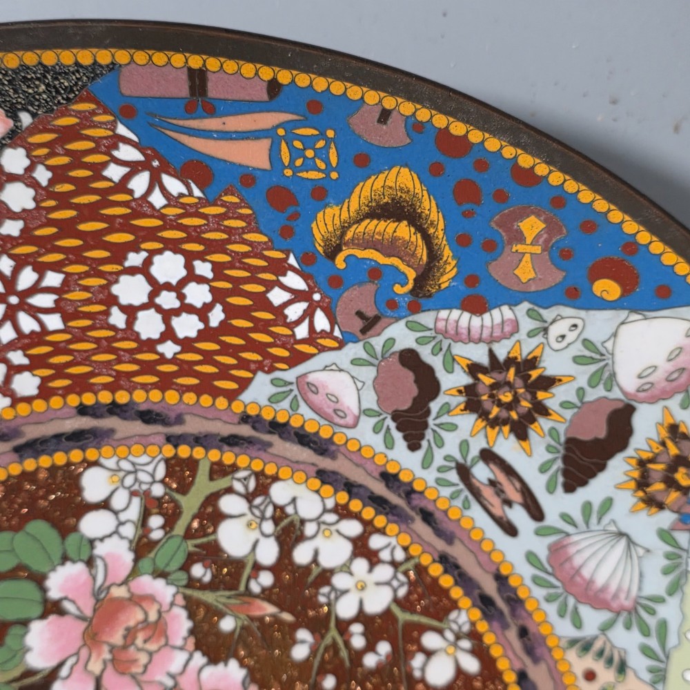 A circular Japanese cloisonne charger featuring a central medallion with birds and peonies on a brown aventurine background surrounded by patterned brocade sections. View IV