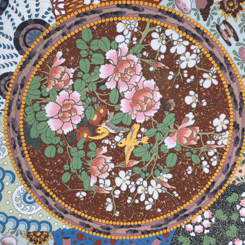 A circular Japanese cloisonne charger featuring a central medallion with birds and peonies on a brown aventurine background surrounded by patterned brocade sections. View VII