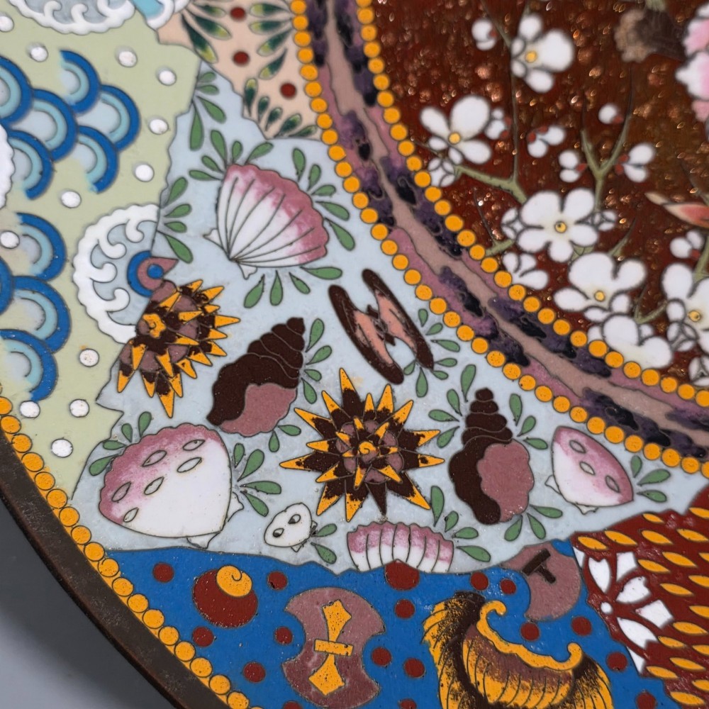 A circular Japanese cloisonne charger featuring a central medallion with birds and peonies on a brown aventurine background surrounded by patterned brocade sections. View IX
