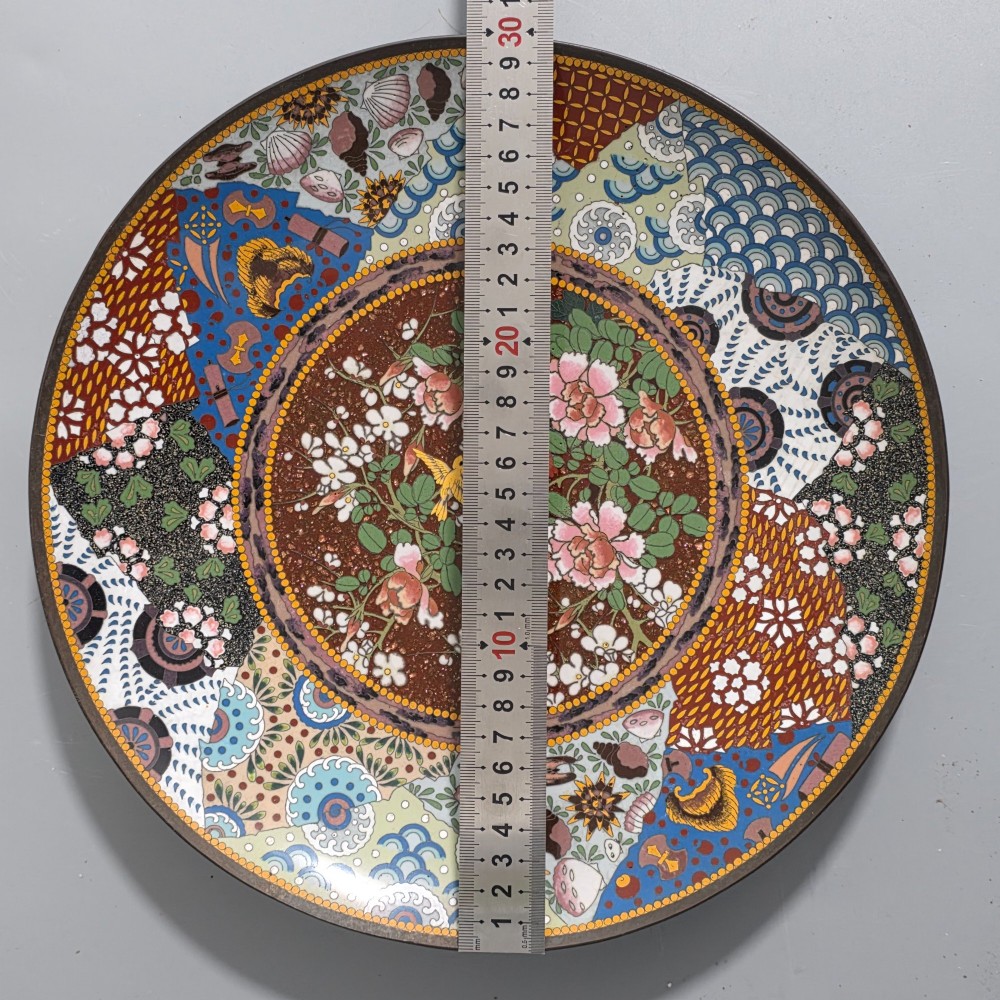 A circular Japanese cloisonne charger featuring a central medallion with birds and peonies on a brown aventurine background surrounded by patterned brocade sections. View XI
