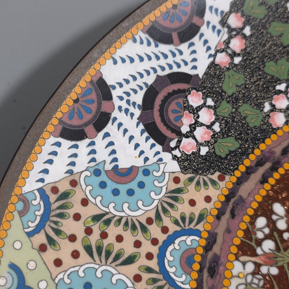 A circular Japanese cloisonne charger featuring a central medallion with birds and peonies on a brown aventurine background surrounded by patterned brocade sections. View XII