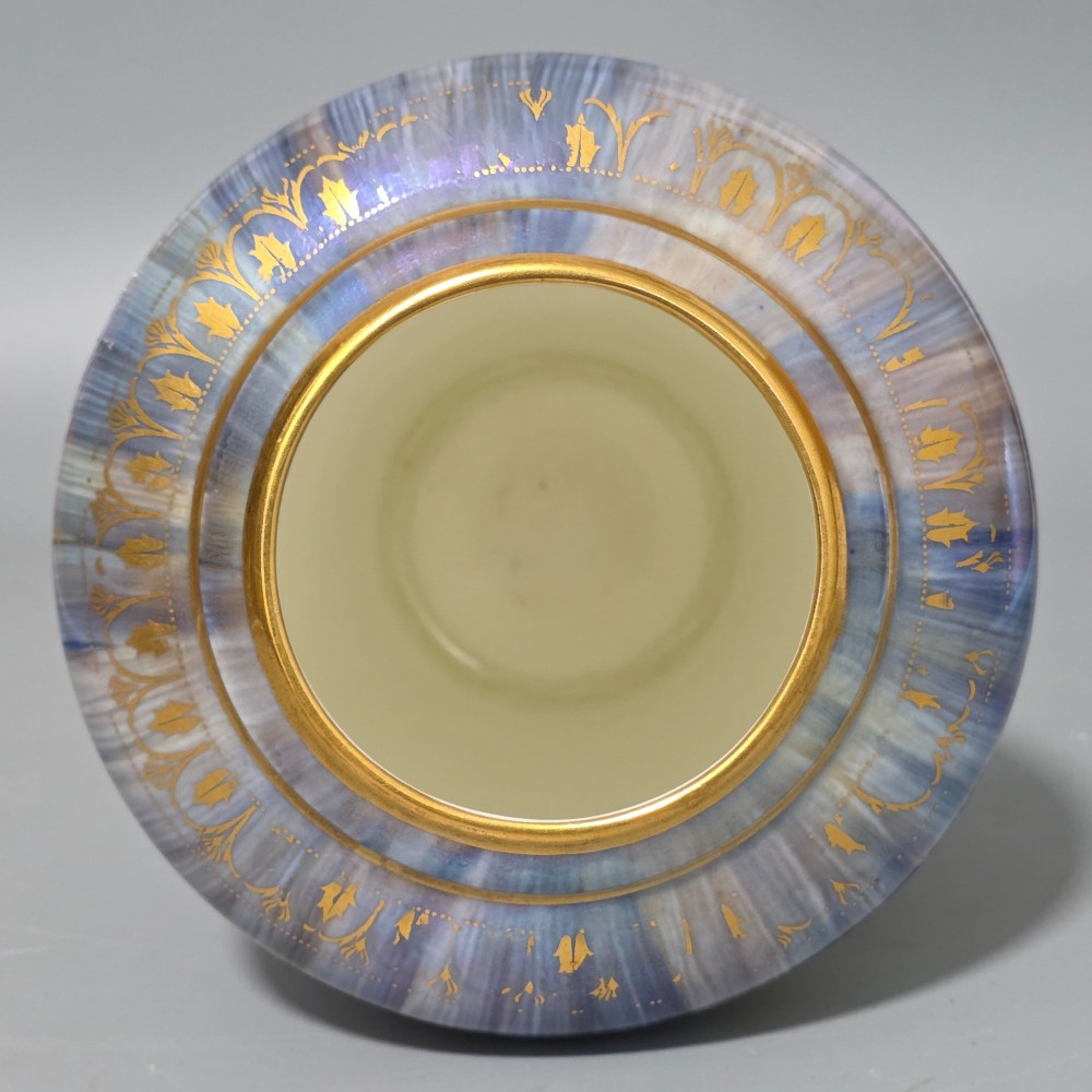 A tapered ceramic vase featuring a streaked iridescent blue lustre glaze and a central circular reserve illustrating a hand-enamelled parrot perched beside a fruit bowl. View XI
