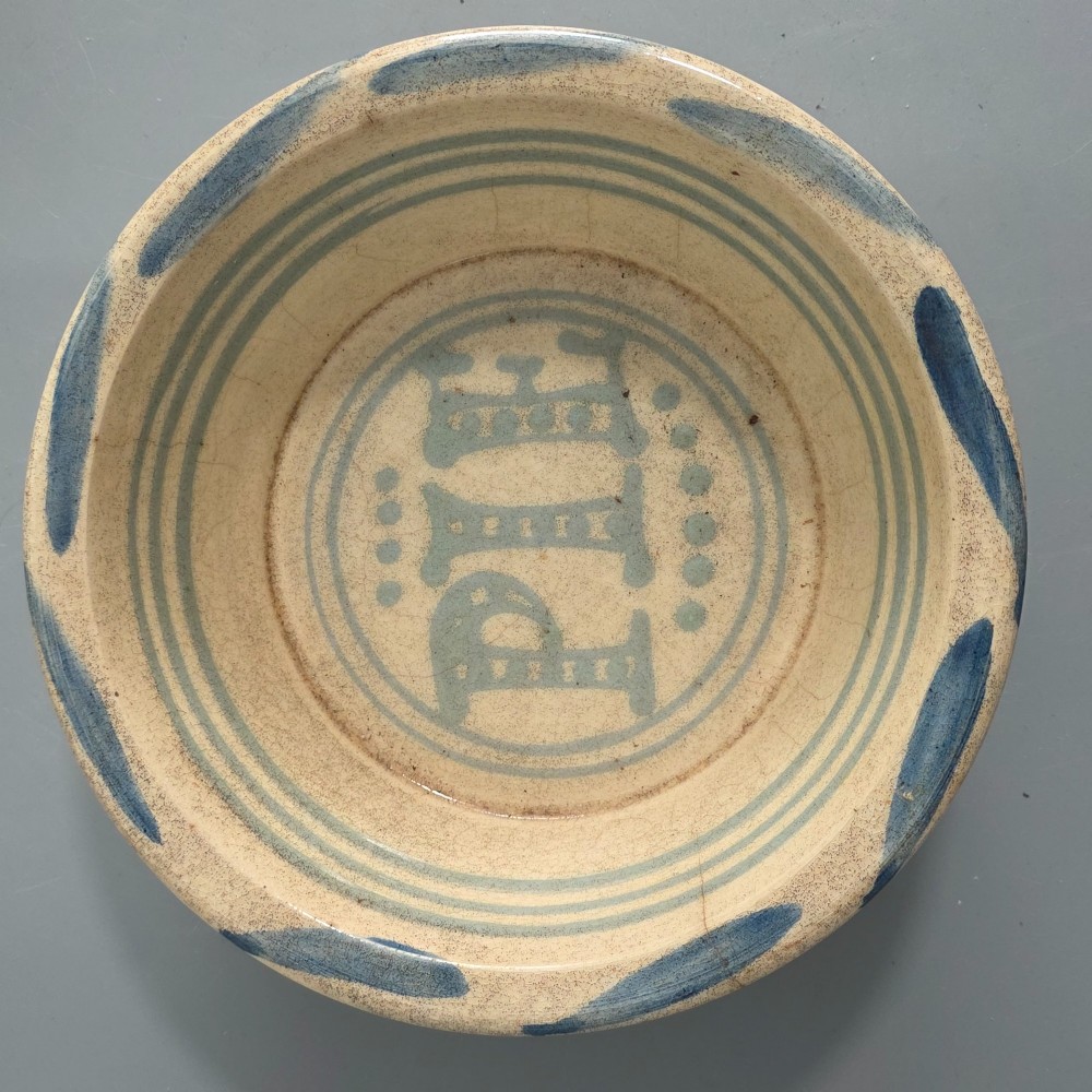 A circular nineteenth-century cream earthenware pie dish featuring the word PIE in blue lettering at the centre and blue decorative rim slashes. View V