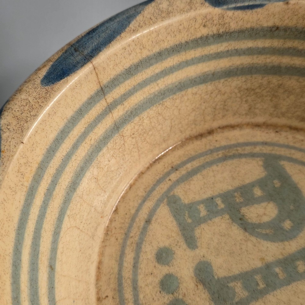A circular nineteenth-century cream earthenware pie dish featuring the word PIE in blue lettering at the centre and blue decorative rim slashes. View VII