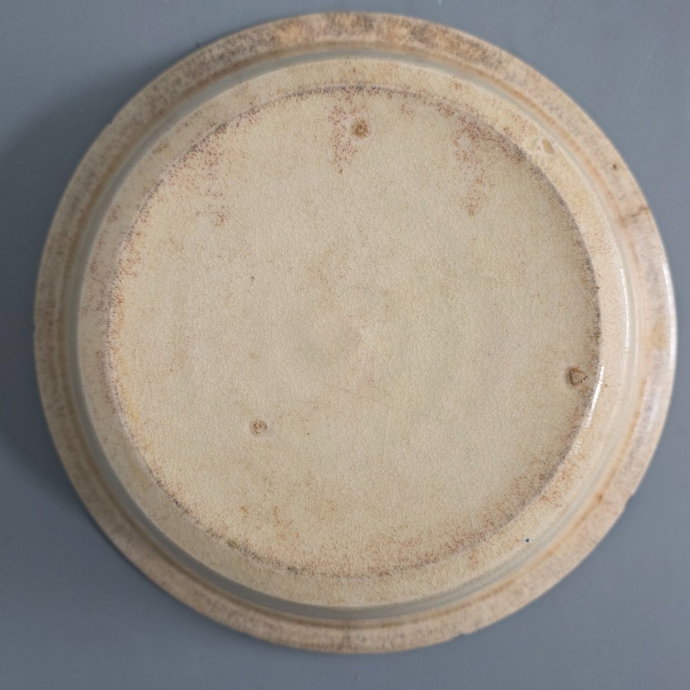 A circular nineteenth-century cream earthenware pie dish featuring the word PIE in blue lettering at the centre and blue decorative rim slashes. View IX