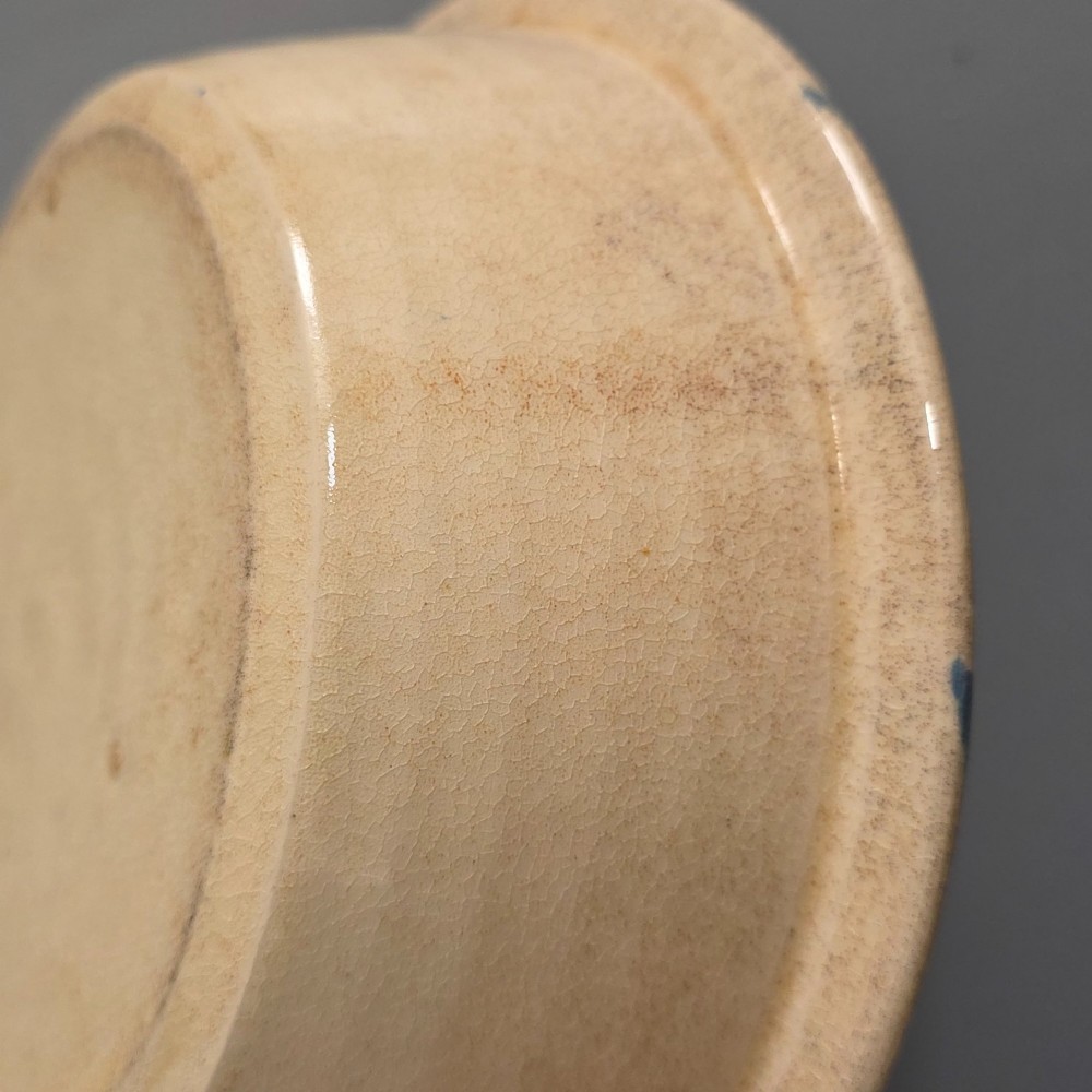 A circular nineteenth-century cream earthenware pie dish featuring the word PIE in blue lettering at the centre and blue decorative rim slashes. View X