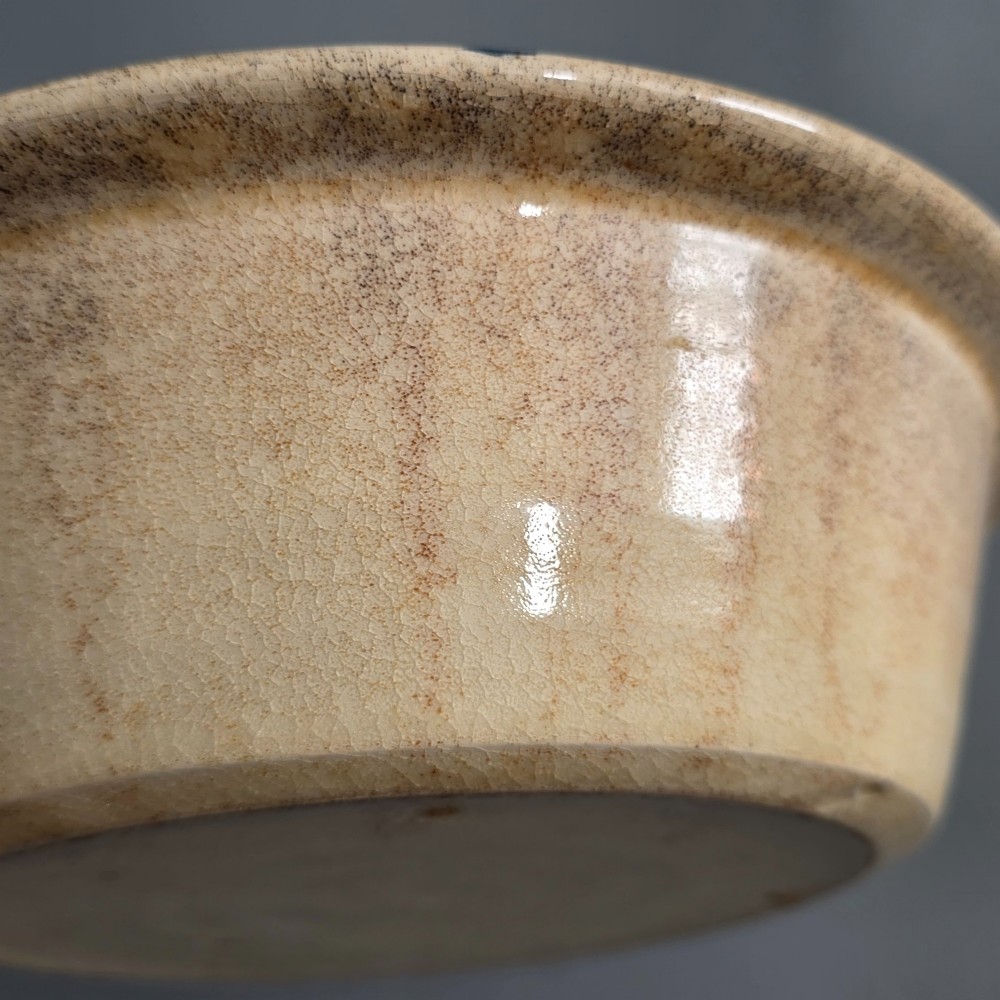 A circular nineteenth-century cream earthenware pie dish featuring the word PIE in blue lettering at the centre and blue decorative rim slashes. View XI