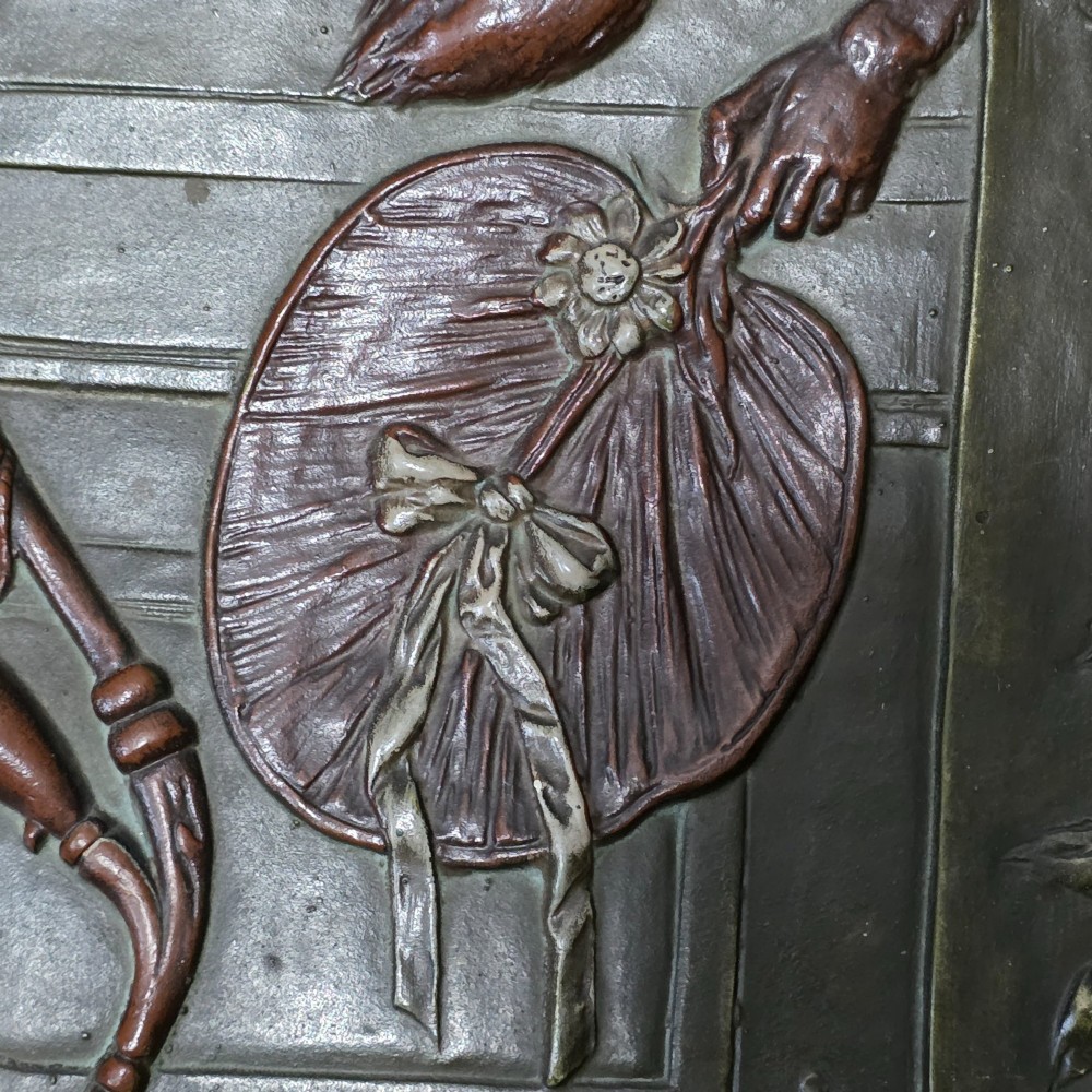 An oval dark brown Austrian terracotta relief plaque depicting a satirical scene of an anthropomorphic monkey family framed by relief floral motifs. View VII