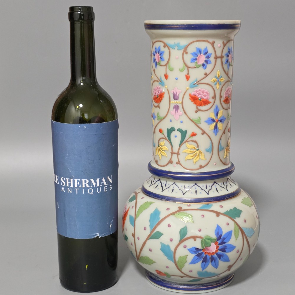 An antique cream opaque glass vase featuring hand-painted floral arabesque enamel patterns in bright colours with gilded accents and cobalt blue bands. View II