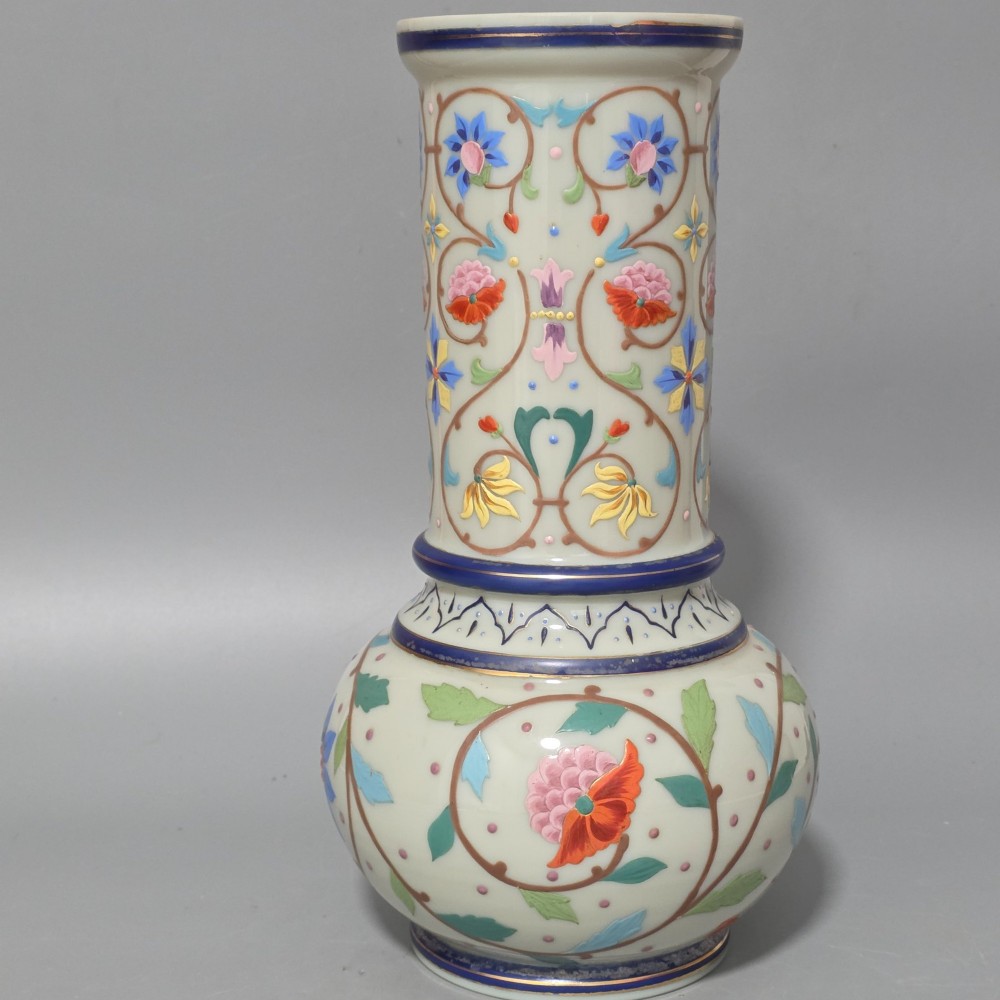An antique cream opaque glass vase featuring hand-painted floral arabesque enamel patterns in bright colours with gilded accents and cobalt blue bands. View III