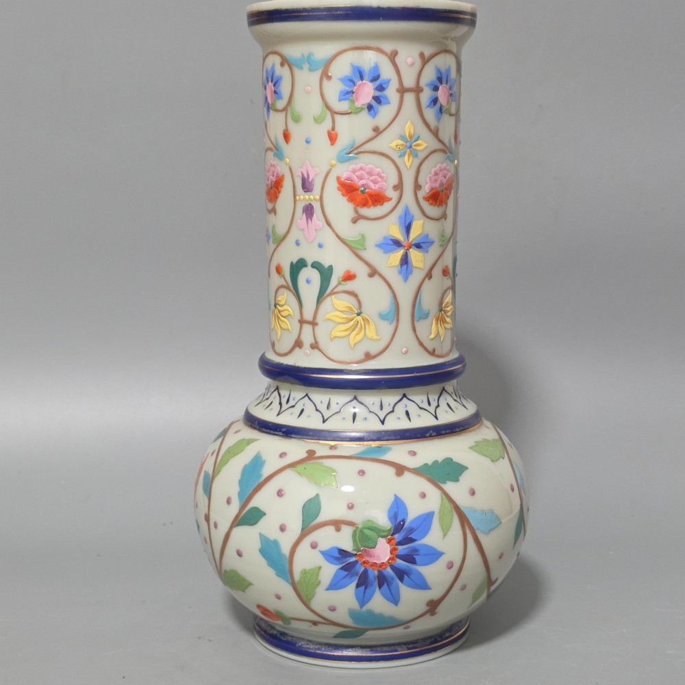 An antique cream opaque glass vase featuring hand-painted floral arabesque enamel patterns in bright colours with gilded accents and cobalt blue bands. View IV