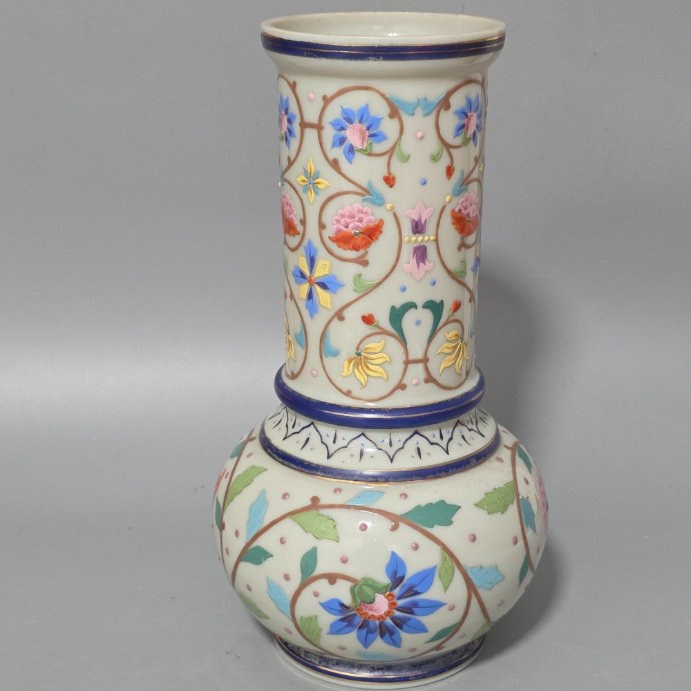 An antique cream opaque glass vase featuring hand-painted floral arabesque enamel patterns in bright colours with gilded accents and cobalt blue bands. View VI