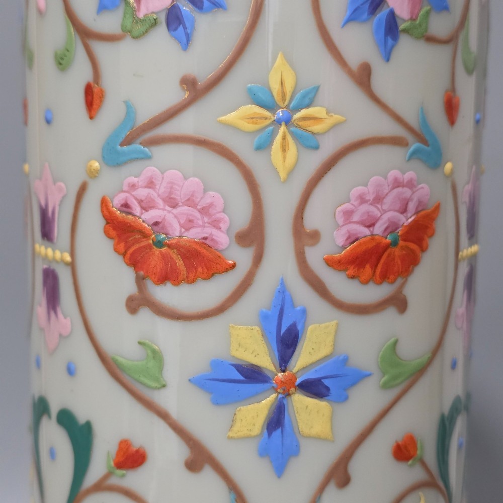 An antique cream opaque glass vase featuring hand-painted floral arabesque enamel patterns in bright colours with gilded accents and cobalt blue bands. View IX