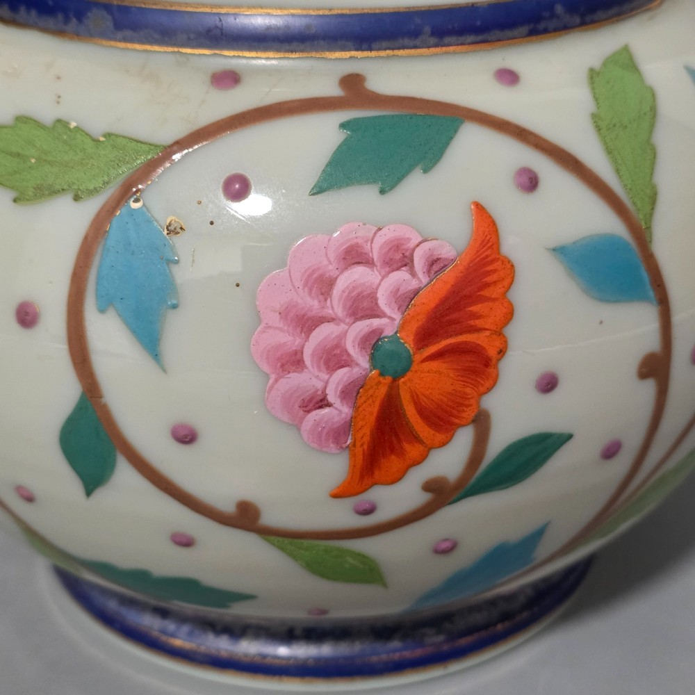 An antique cream opaque glass vase featuring hand-painted floral arabesque enamel patterns in bright colours with gilded accents and cobalt blue bands. View XI