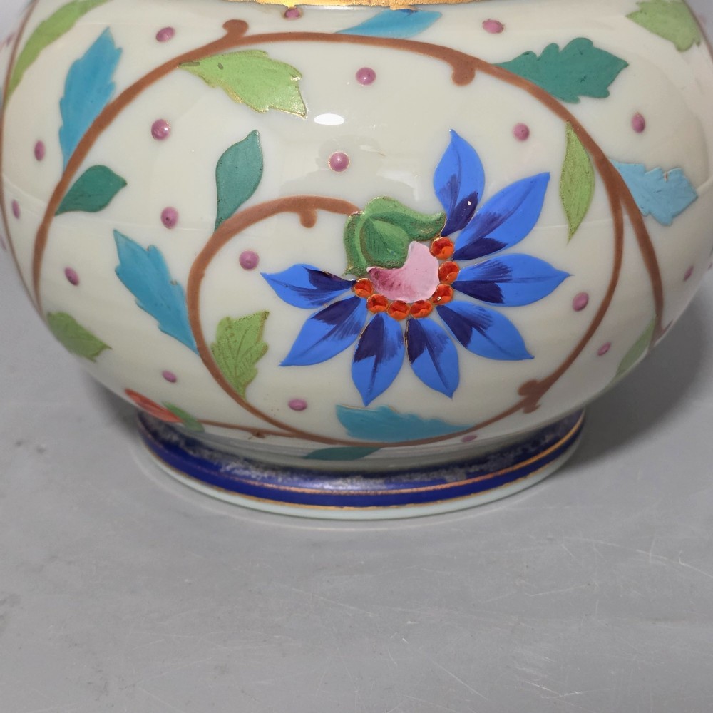 An antique cream opaque glass vase featuring hand-painted floral arabesque enamel patterns in bright colours with gilded accents and cobalt blue bands. View XII