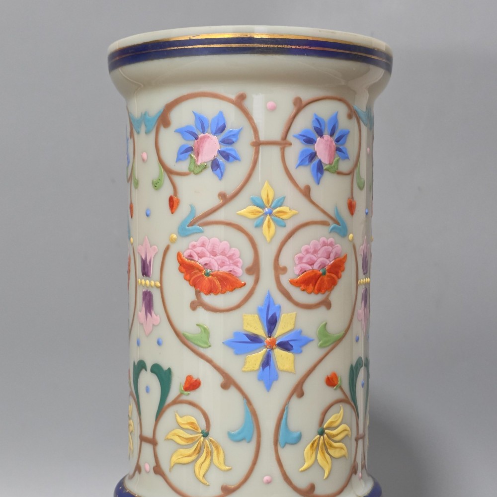An antique cream opaque glass vase featuring hand-painted floral arabesque enamel patterns in bright colours with gilded accents and cobalt blue bands. View XV