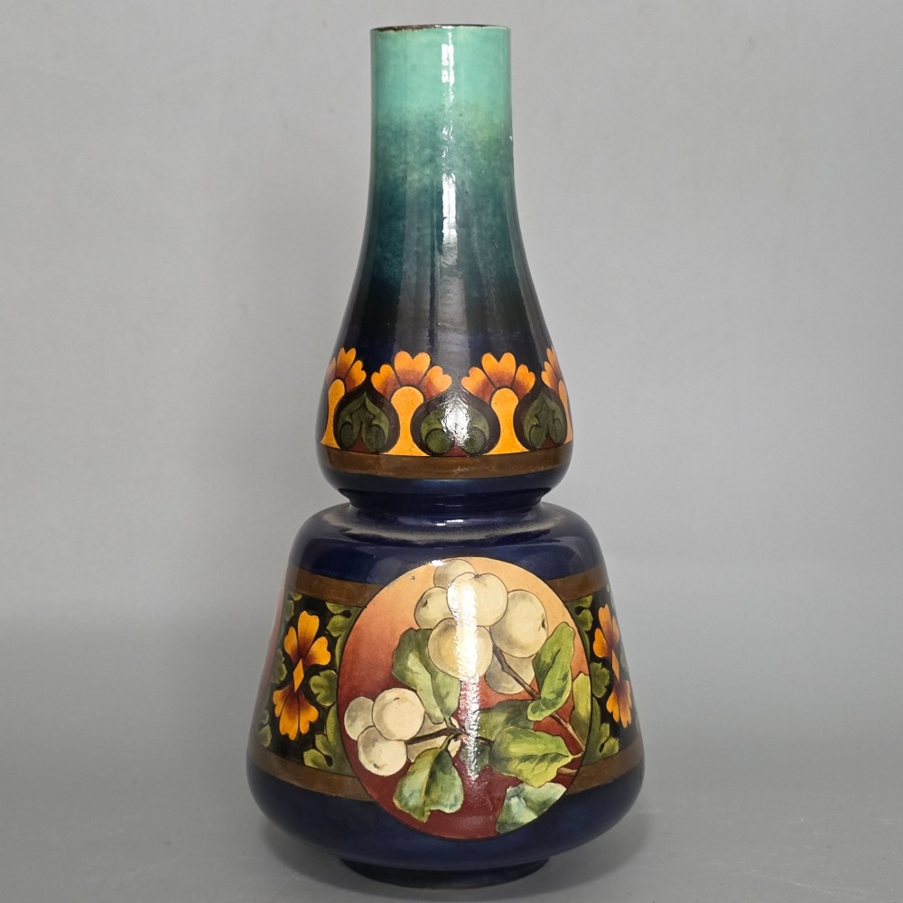 A late Victorian double-gourd earthenware vase with hand-painted fruit roundels, stylized floral bands, and a gradient turquoise to blue neck. View II