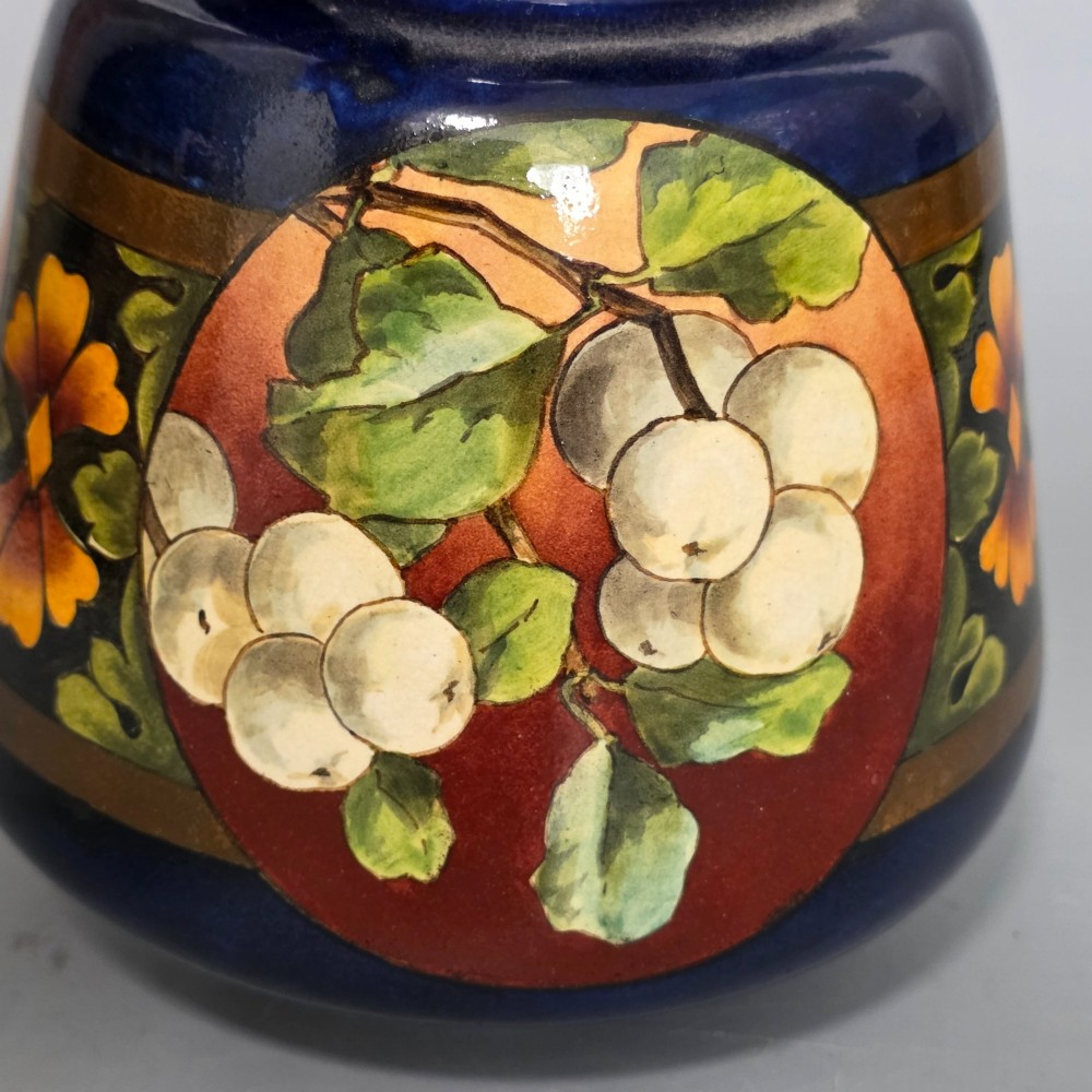 A late Victorian double-gourd earthenware vase with hand-painted fruit roundels, stylized floral bands, and a gradient turquoise to blue neck. View V